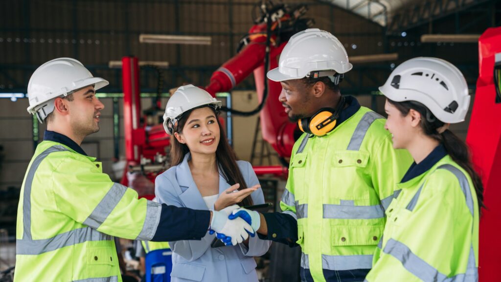 A group of workers wearing safety gear. Worker industry join hand for collaboration.